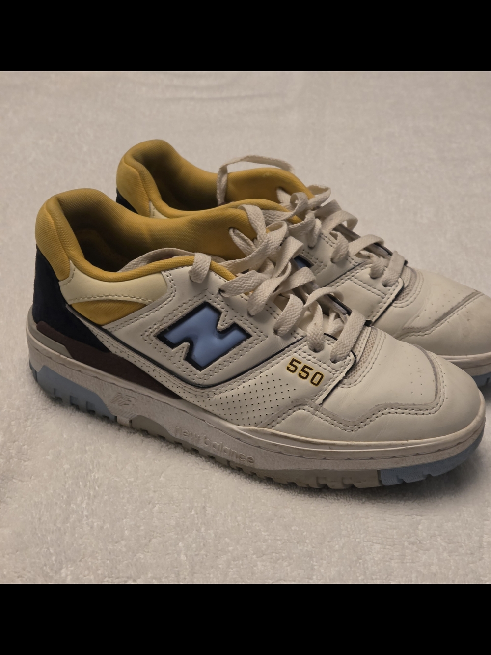 New Balance 550 White Sneakers with Yellow Lining and Light Blue Logo